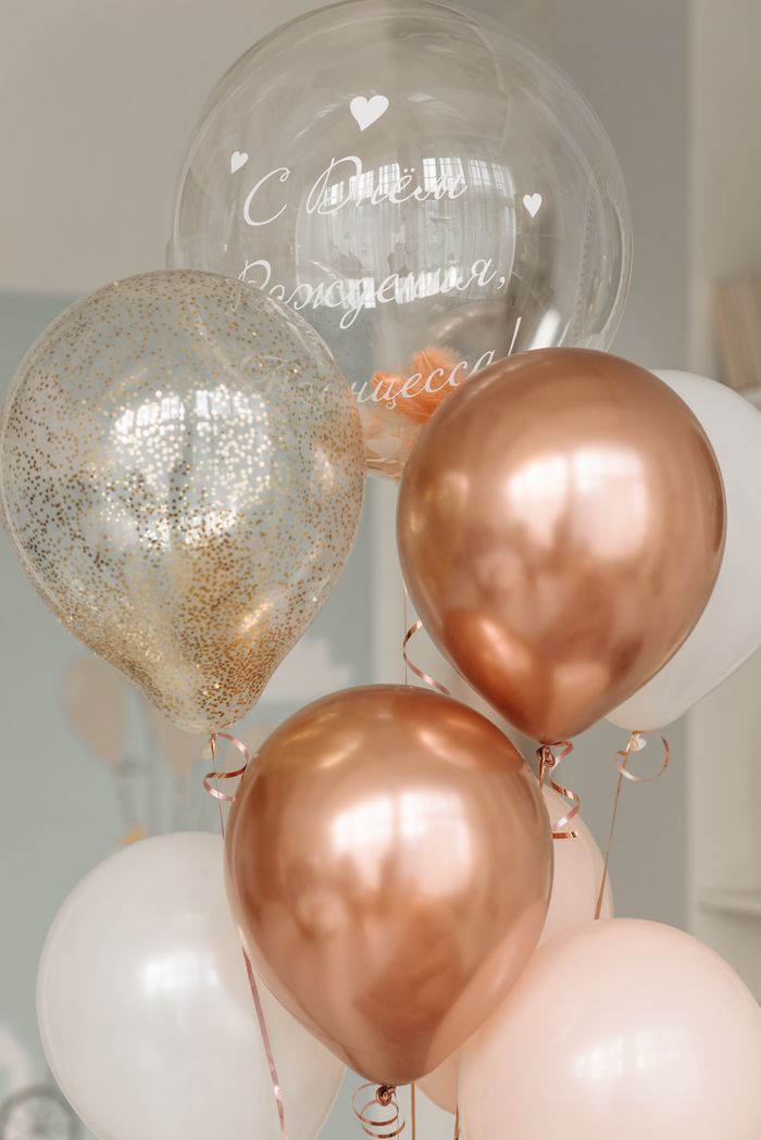 gallery-02 Elegant rose gold and transparent balloons arranged for a birthday celebration indoors.